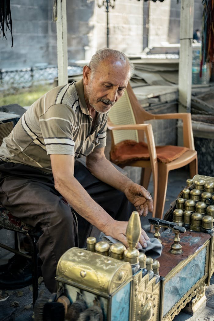 Senior man polishing shoes at a traditional shoeshine stall in a city setting.